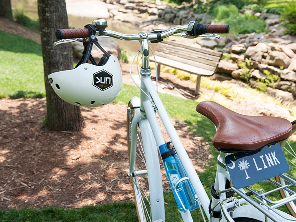 a bike parked in a park with a helmet on the handlebars a bike parked in a park with a helmet on the handlebars at Link Apartments® Canvas, Georgia